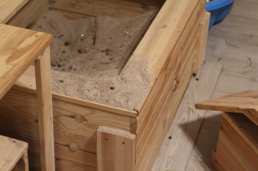 Das Foto zeigt eine Buddelkiste mit Sand