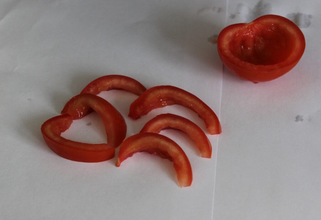 Das Foto zeigt Tomatenschnitze, die für Kaninchen zubereitet sind